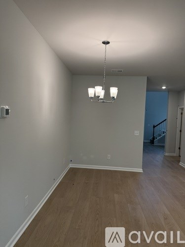 A room with a chandelier and Avail logo on the floor.