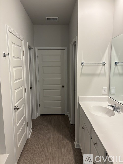 A bathroom with a sink, mirror, and two doors.