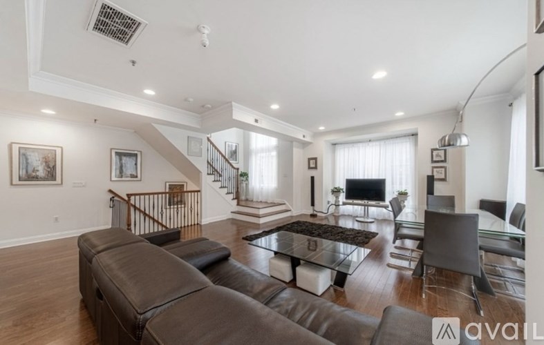 A spacious living room with a staircase and a television.