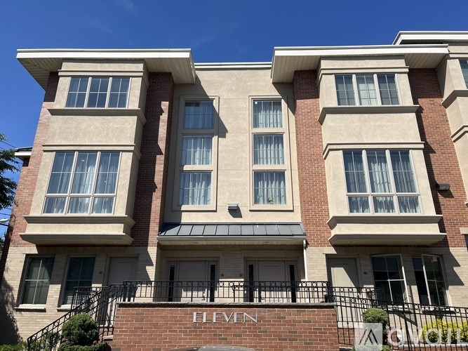 The image shows a multi-story building with a sign that reads "ELEVEN".