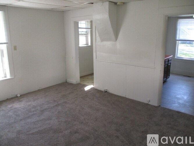 A room with white walls and carpeted floor.