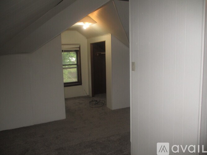 A room with a window and a door is available for rent.