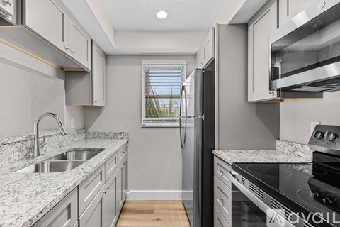 A modern kitchen with granite countertops and stainless steel appliances.