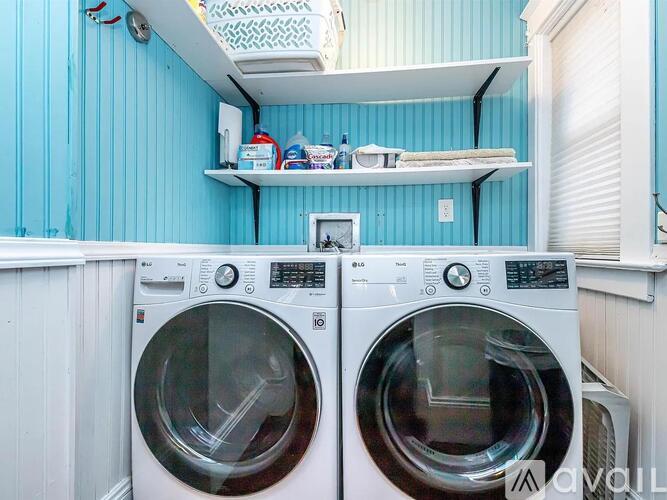 Two front loading washing machines in a small laundry room.