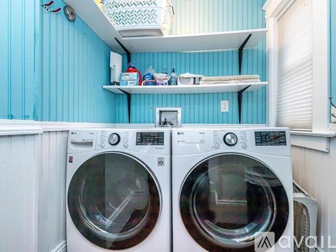 Two front loading washing machines in a small laundry room.