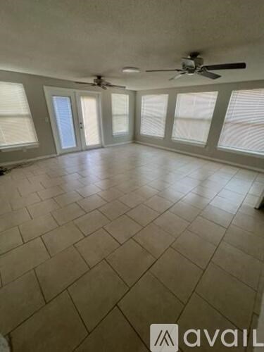 A room with a ceiling fan and tiled flooring.