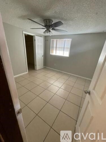 A room with a ceiling fan and tiled flooring.