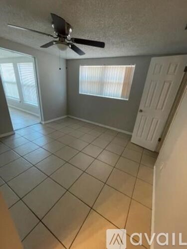 A room with a ceiling fan and tiled flooring.