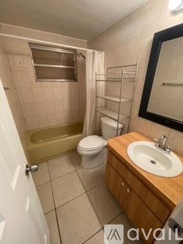 A bathroom with a wooden vanity and a white toilet.