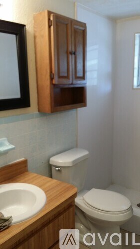 A small bathroom with a toilet, sink and medicine cabinet.