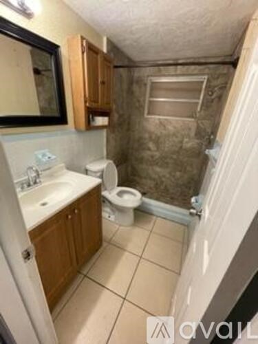 A bathroom with a toilet, sink, and shower.