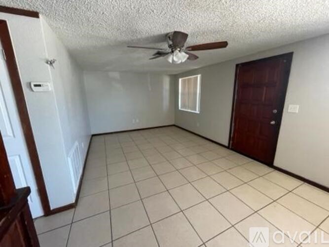 A room with a ceiling fan and tile flooring.