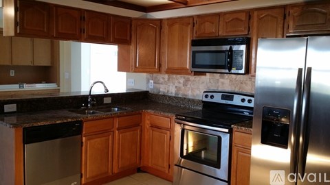 A kitchen with wooden cabinets and stainless steel appliances.