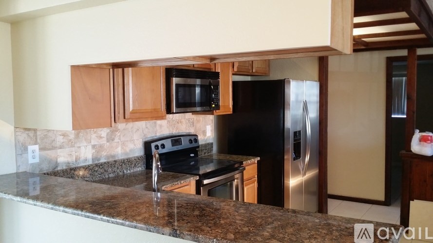 A kitchen with a granite countertop and stainless steel appliances.