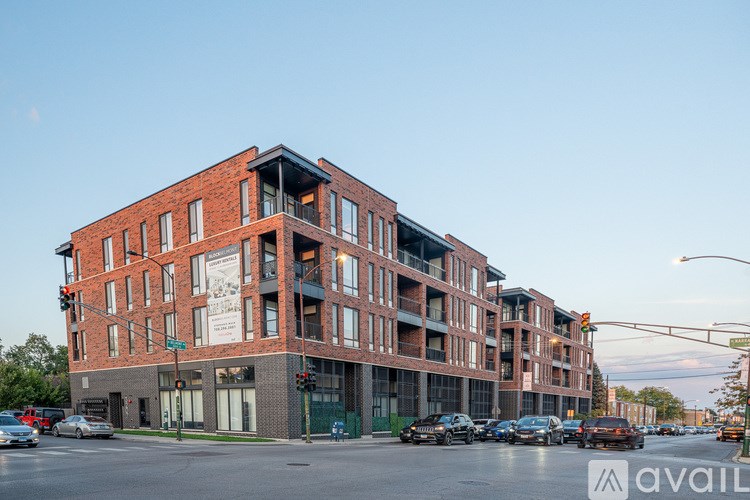 A large red brick building with a black awning on the corner of a street.