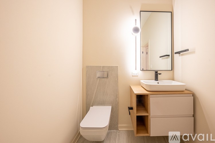 A bathroom with a toilet, sink, and mirror.