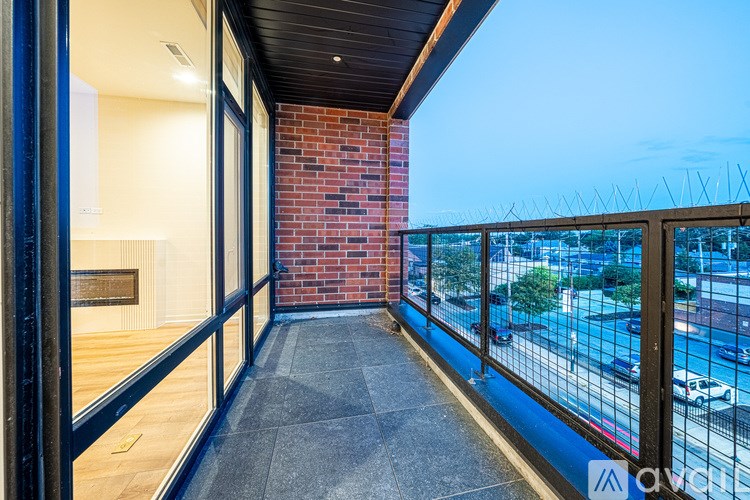 A balcony with a brick wall and a view of the street below.