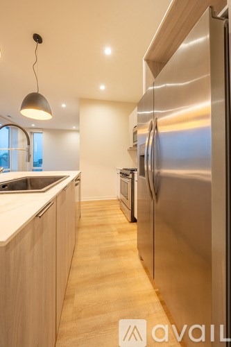 A modern kitchen with a stainless steel refrigerator and wooden cabinets.