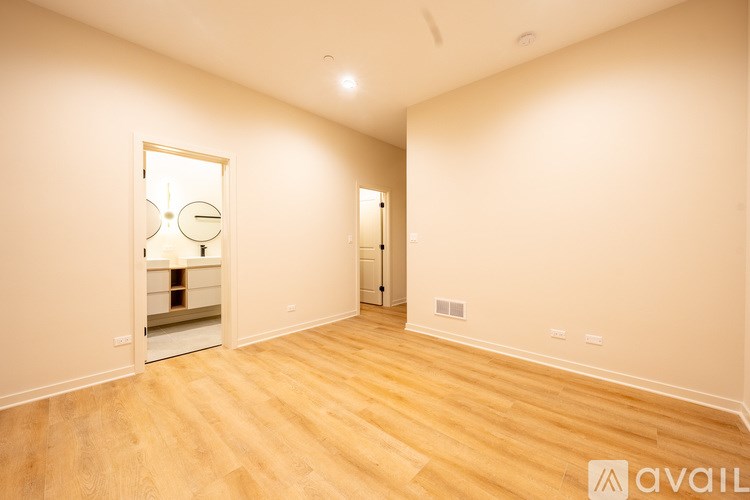 A room with wooden flooring and a mirror on the wall.