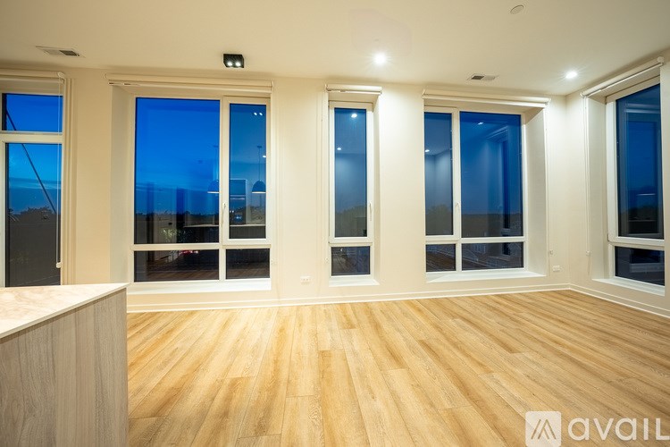 A room with wooden floors and large windows.