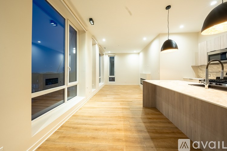 A modern kitchen with wooden floors and a long island.