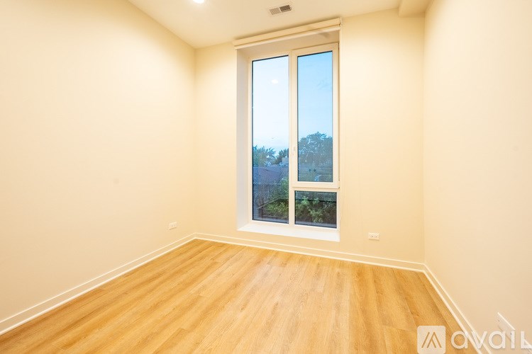 A room with a large window and wooden flooring.