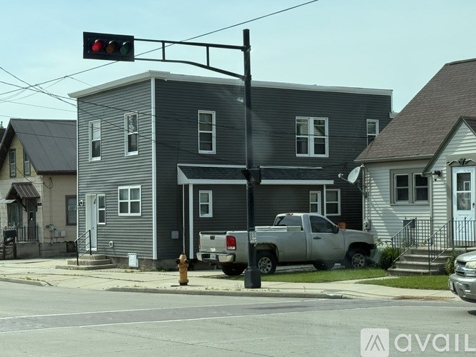 A red traffic light is hanging over a street.