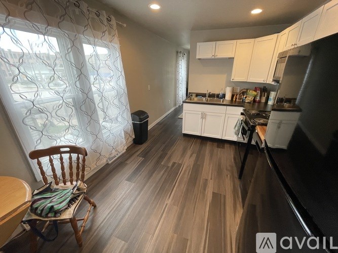 A kitchen with a wooden floor and white cabinets.