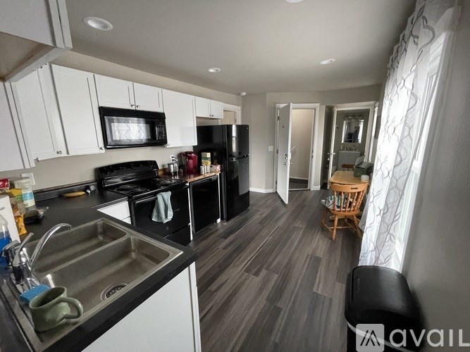 A kitchen with black appliances and white cabinets.