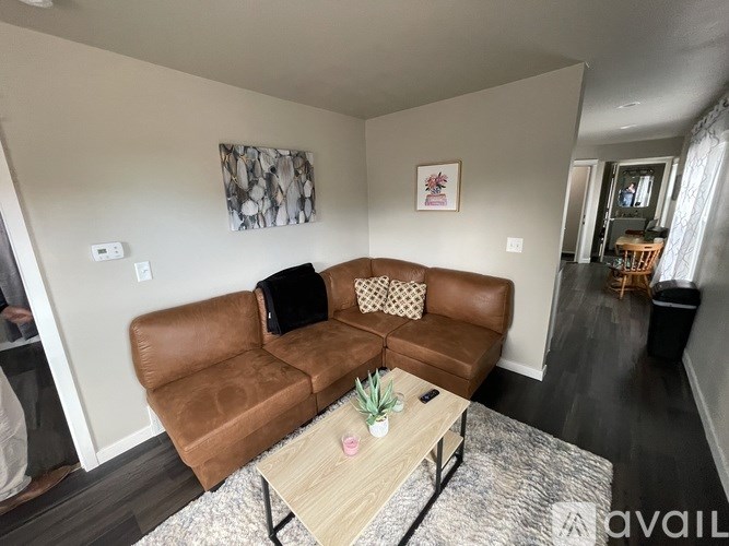 A living room with a brown couch and a coffee table.