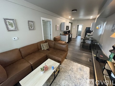 A living room with a brown leather couch and a wooden coffee table.