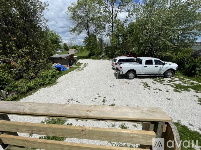 A white pickup truck is parked on a gravel driveway.