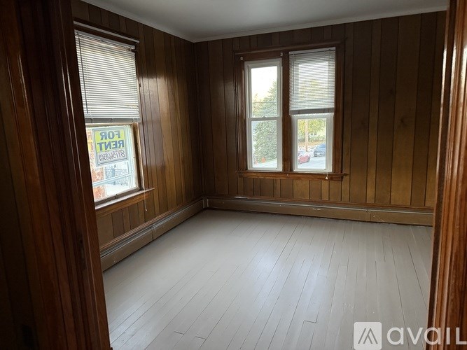 A room with wooden walls and a window with blinds.