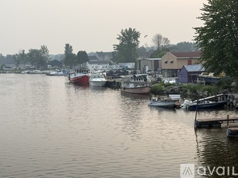 A calm body of water with boats docked and buildings in the background.