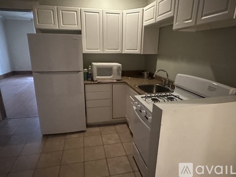 A kitchen with white appliances and cabinets.