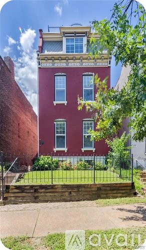 A red brick building with a green lawn in front.