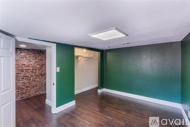 A room with a brick wall and a white door.