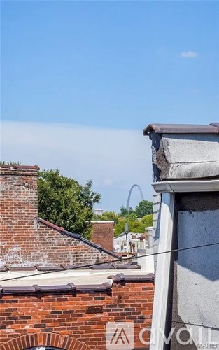 A building with a red brick chimney and a grey roof.