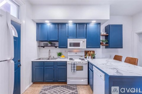 A kitchen with blue cabinets and a white island.