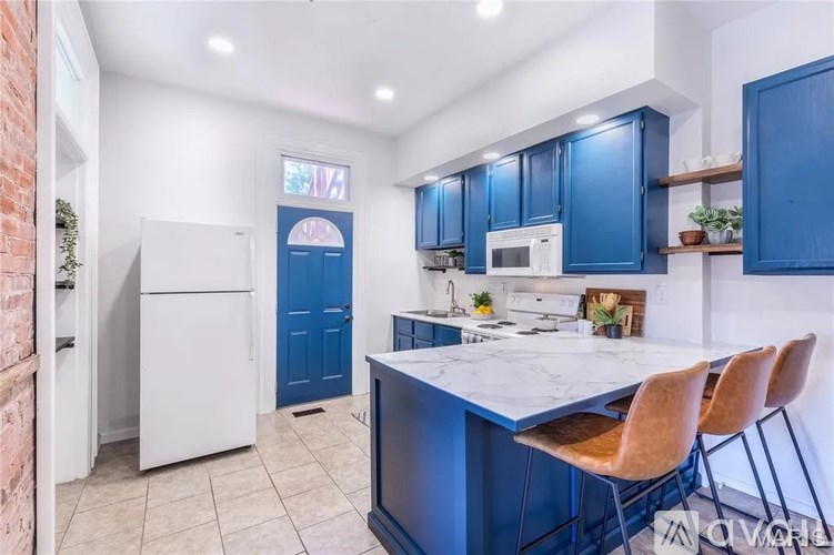 A kitchen with blue cabinets and a white island.