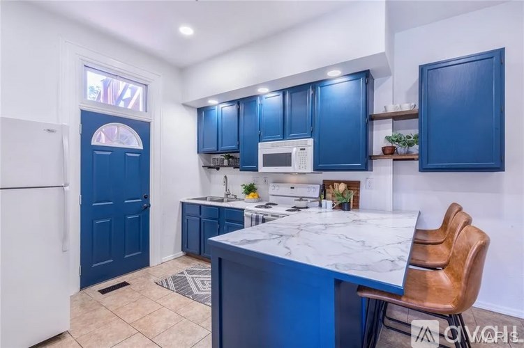 A kitchen with blue cabinets and a white countertop.