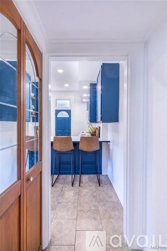 A hallway with two chairs and a table with a plant on it.