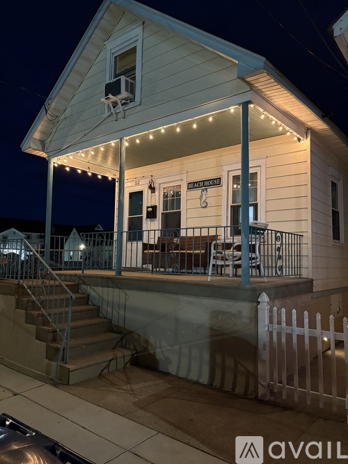 A white house with a porch and a sign that says "The House".