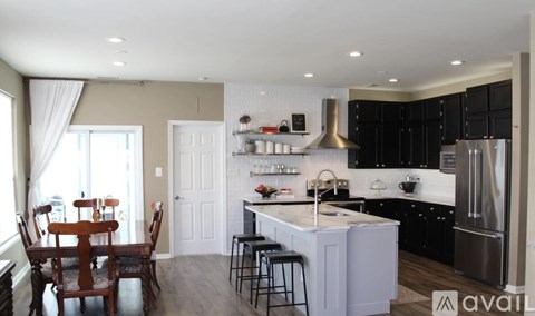 A kitchen with a dining table and chairs.