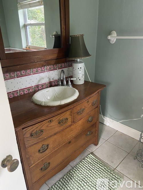 A bathroom with a sink and a mirror.