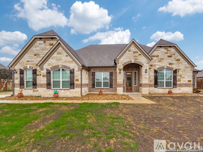 A house with a stone facade and a grey roof.