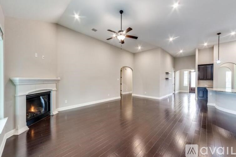 A spacious room with a fireplace and wood flooring.