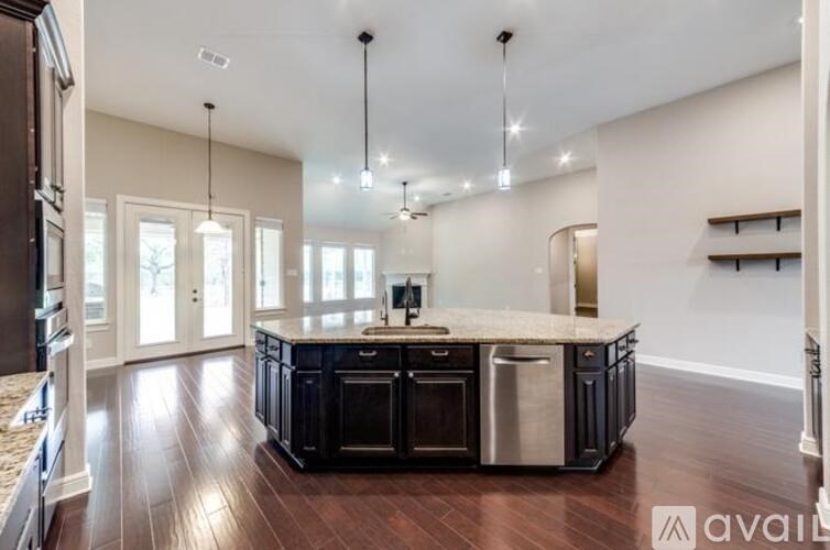 A modern kitchen with dark wood floors and a center island.