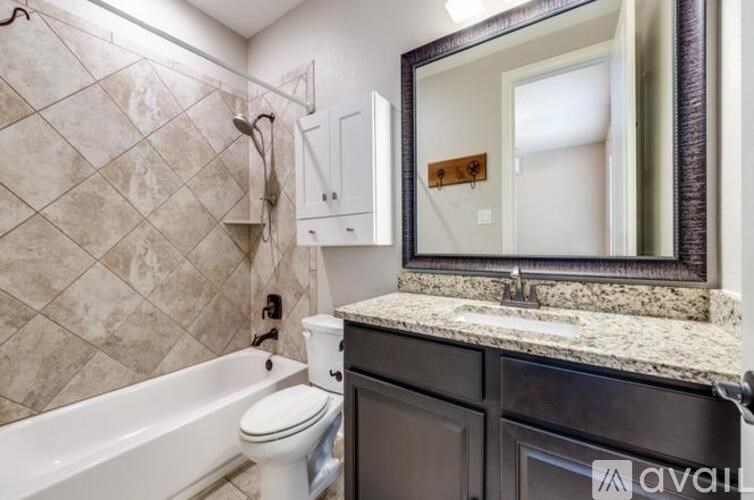 A bathroom with a white toilet, a bathtub, and a sink.