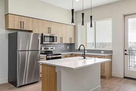 A modern kitchen with a stainless steel refrigerator and wooden cabinets.
